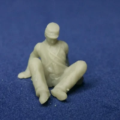 Wounded sitting on ground in kepi