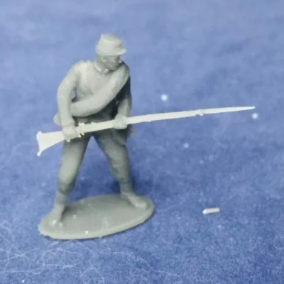 Confederate private in kepi and rolled blanket in defensive pose